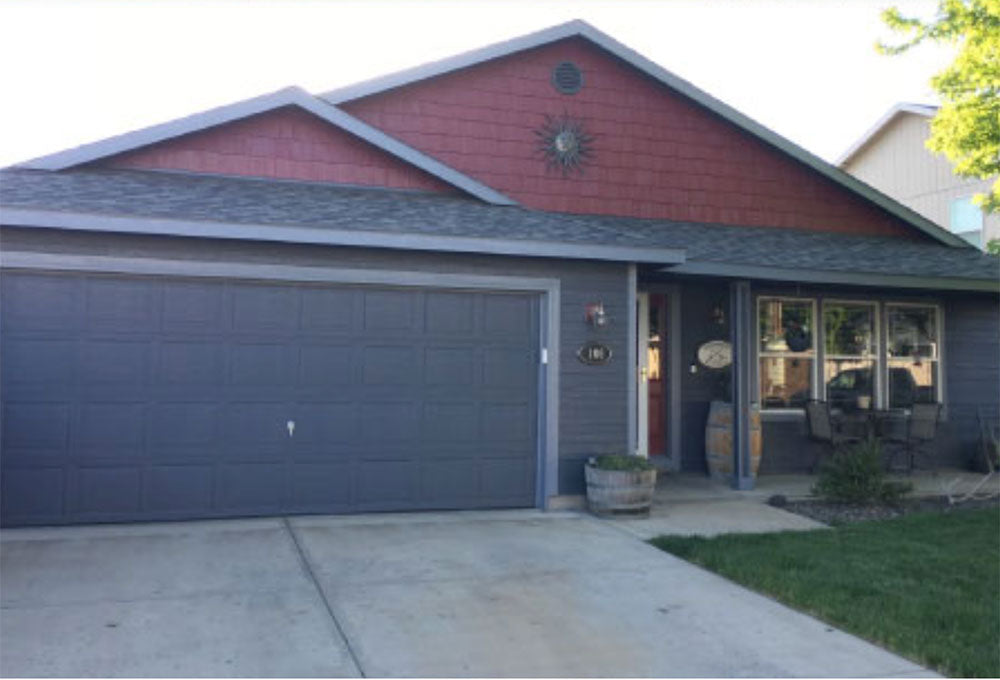 Front view of a house painted dark grey and burgundy with exterior paint.