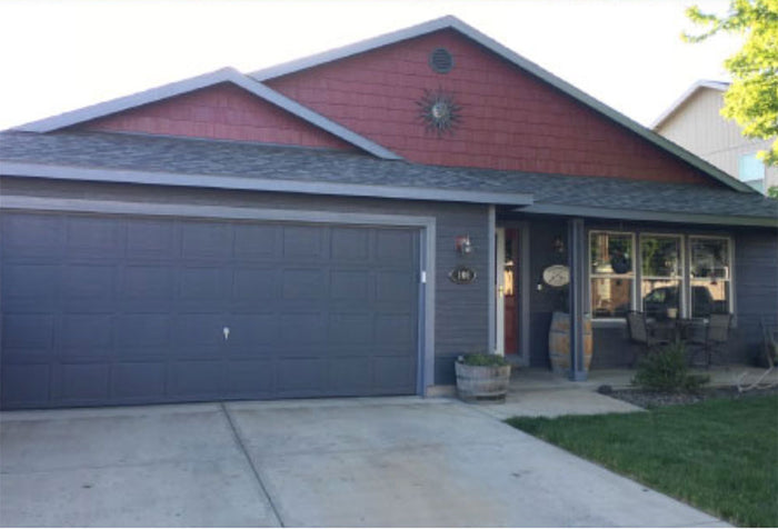 Front view of a house painted dark grey and burgundy with exterior paint.