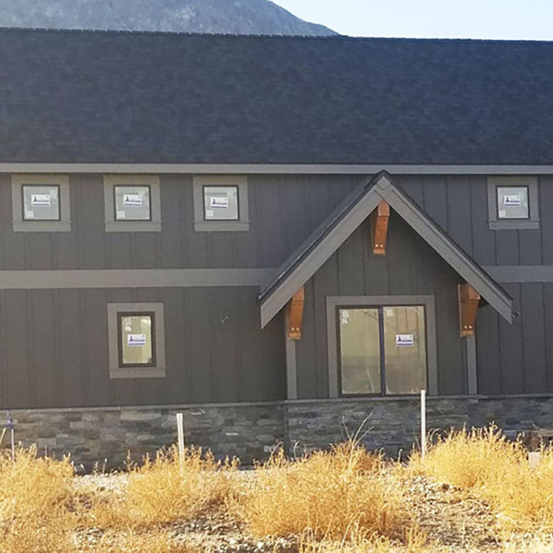 Exterior of a freshly painted barn style building with dark grey paint from Standard Paint & Flooring. 