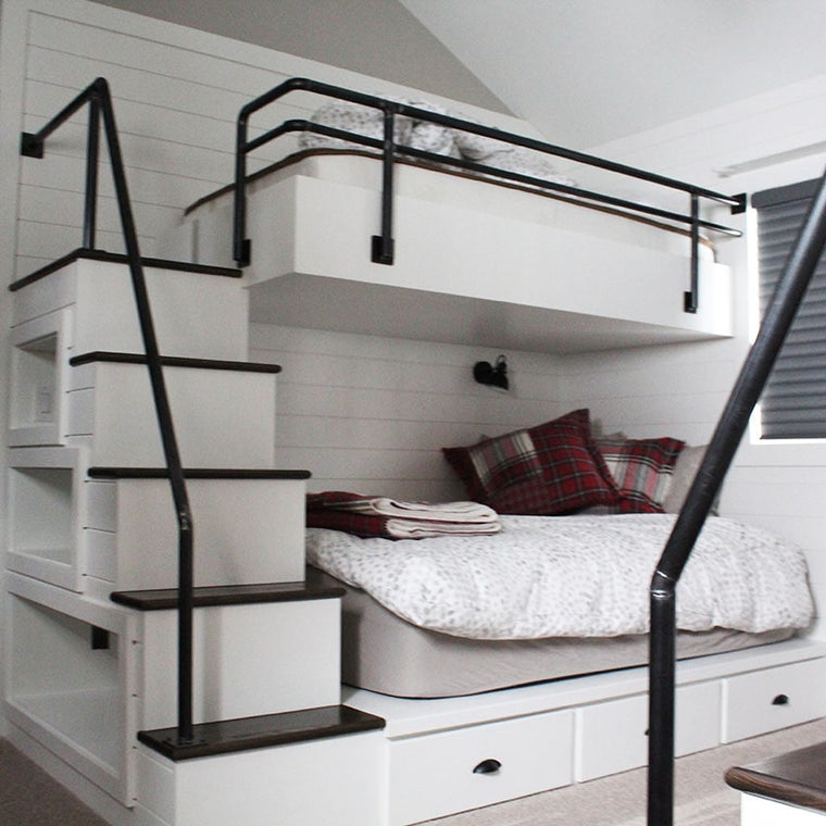 custom white bunk beds, with black railings, and wood stairs by Modern Millwork