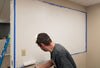 A painter paints a dry erase board using dry erase paint.