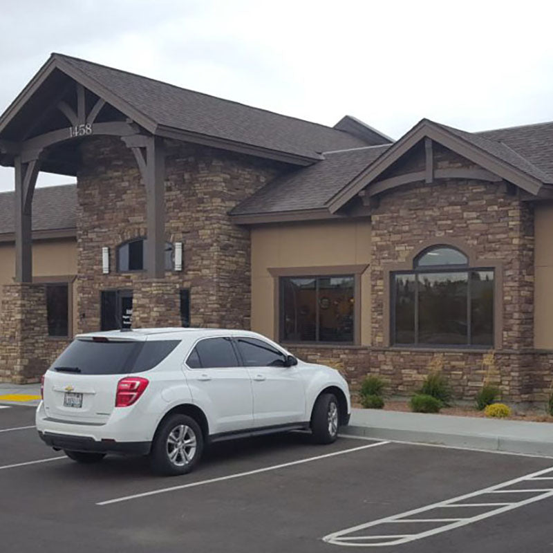 Exterior of a renovated commercial building with dark brick and stucco by Standard Paint & Flooring.