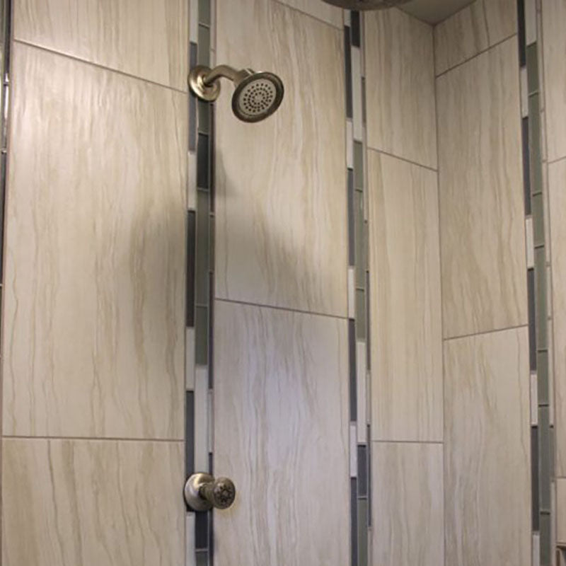 Close up view of inside a renovated shower with a tile wall design from Standard Paint & Flooring.
