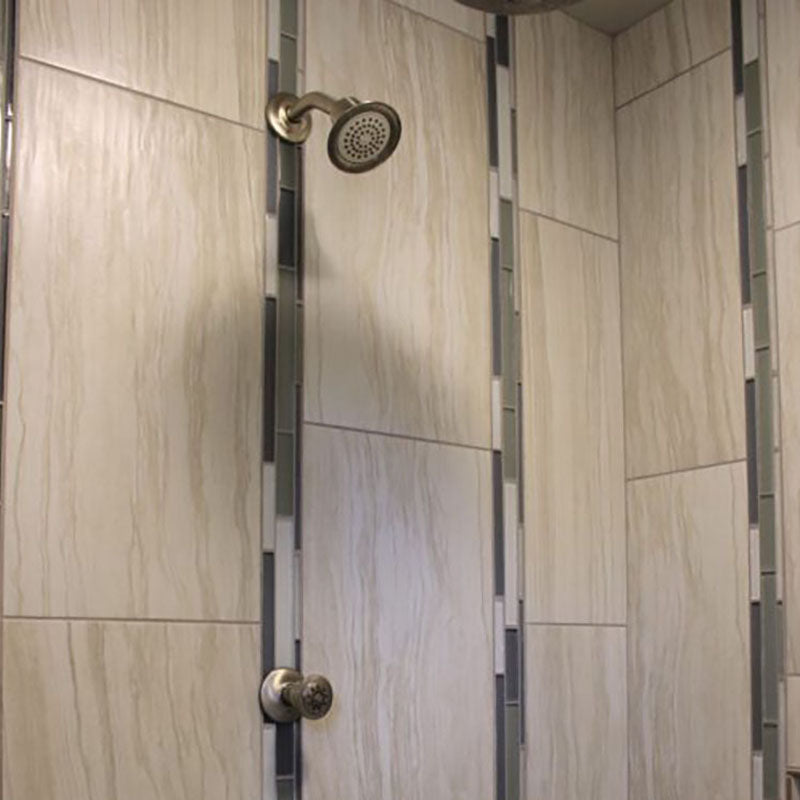 Close up view of inside a renovated shower with a tile wall design from Standard Paint & Flooring.