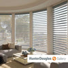 A living room with Hunter Douglas window shades, available at Standard Paint & Flooring.